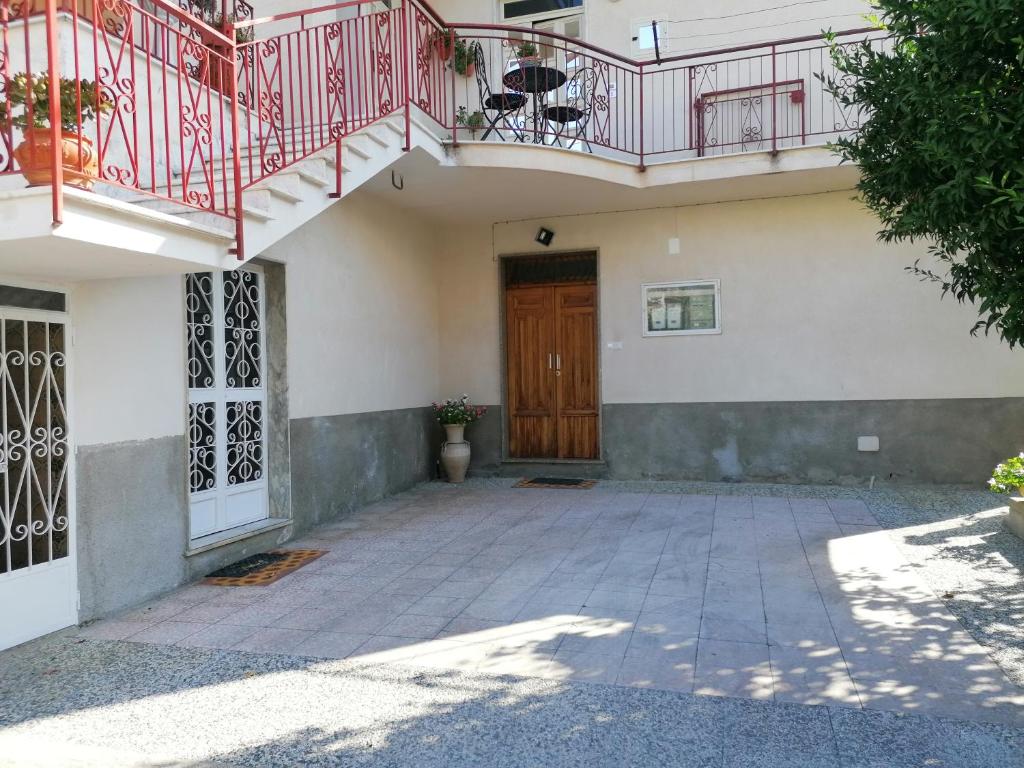 una casa con porta in legno e balcone di DA NONNA ROSA a Roccella Ionica