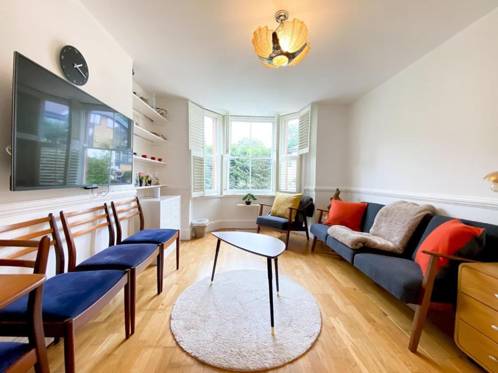 uma sala de estar com um sofá e uma mesa em Pass the Keys Stockwell Apartment with a Private Garden em Londres