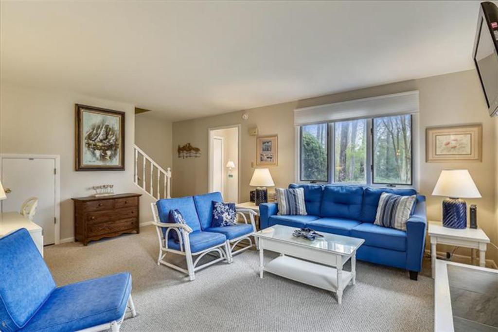 a living room with blue couches and a table at Bethany Pines -- 412 Bethany Drive in Bethany Beach
