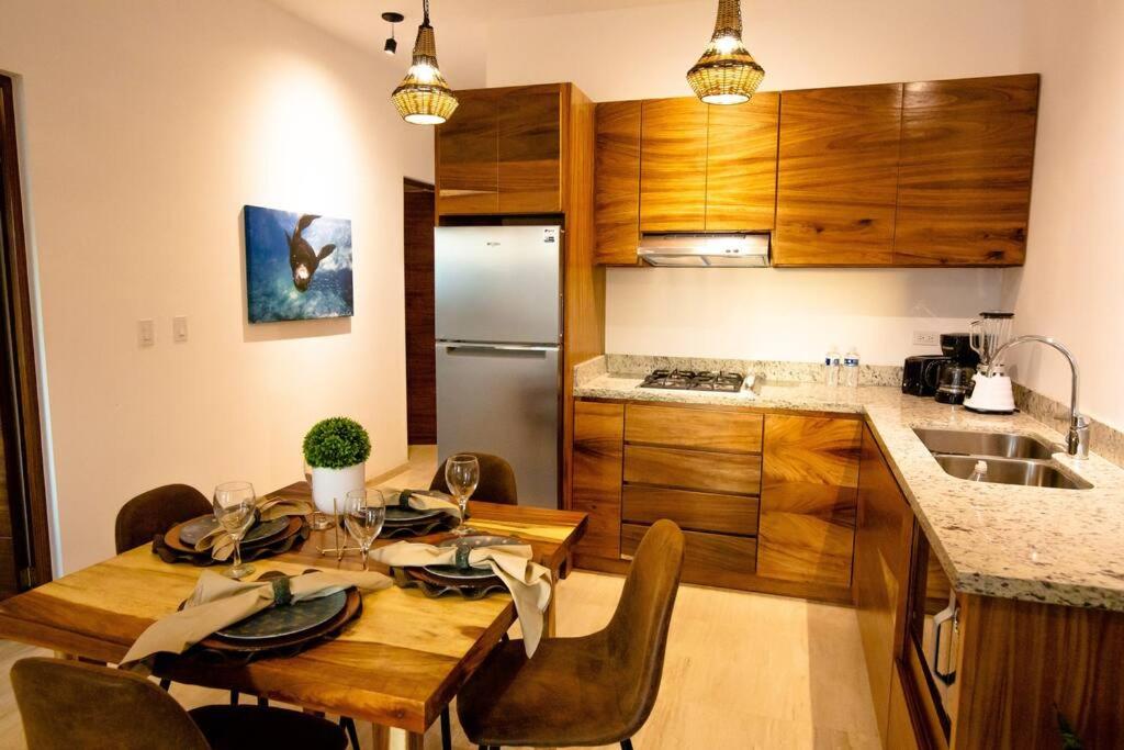 uma cozinha com uma mesa de madeira com cadeiras e uma cozinha com um frigorífico em Ancla Baja Living Condominio nuevo con vista 4 em La Paz