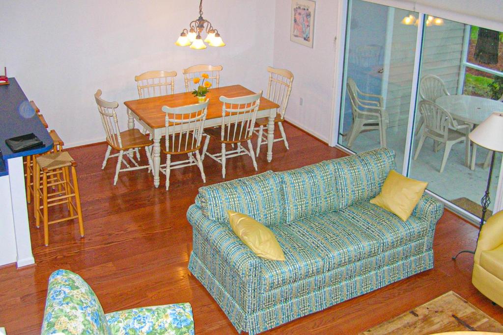 Una sala de estar con un sofá, una mesa y sillas. en Salt Pond -- 10 Spinnaker Vilage, en Bethany Beach