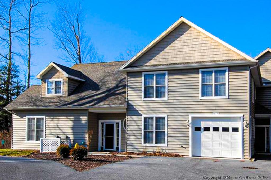 a brown house with a white garage at Salt Pond -- 13 Skipjack Village in Bethany Beach