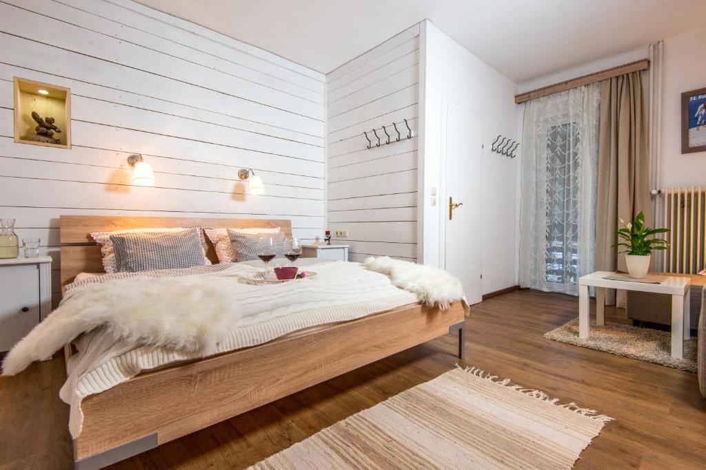 um quarto com uma cama grande com lençóis brancos e pele em Haus Emma em Bad Gastein