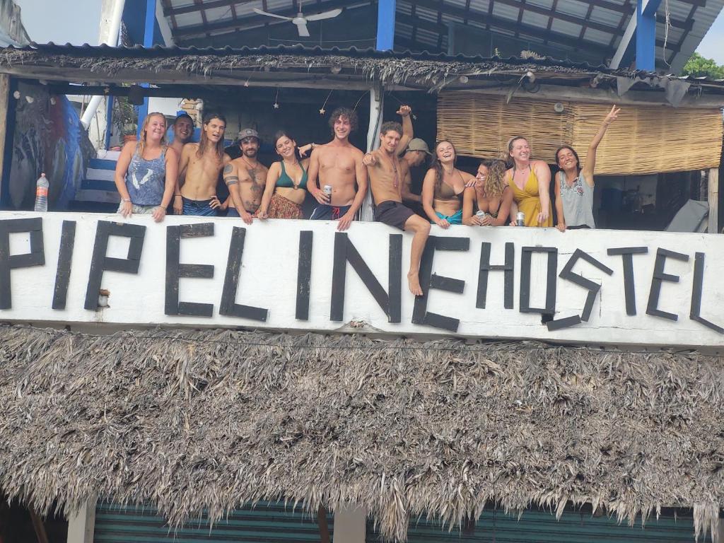 a group of people standing on top of a sign at Pipeline Hostel in Puerto Escondido