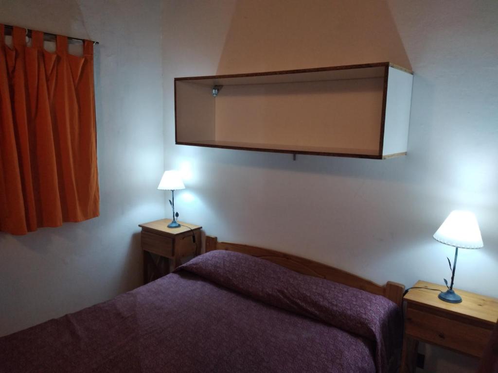a bedroom with a bed and two lamps on tables at Acutun in Mar de Ajó