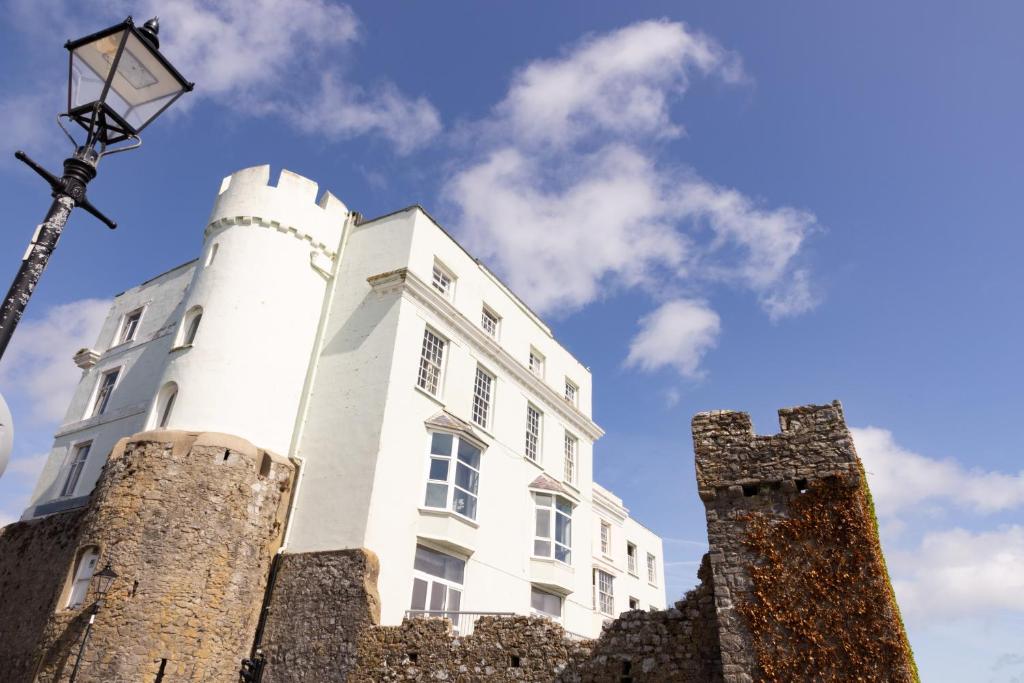 a white building with two towers and a street light at Imperial Hotel Tenby in Tenby