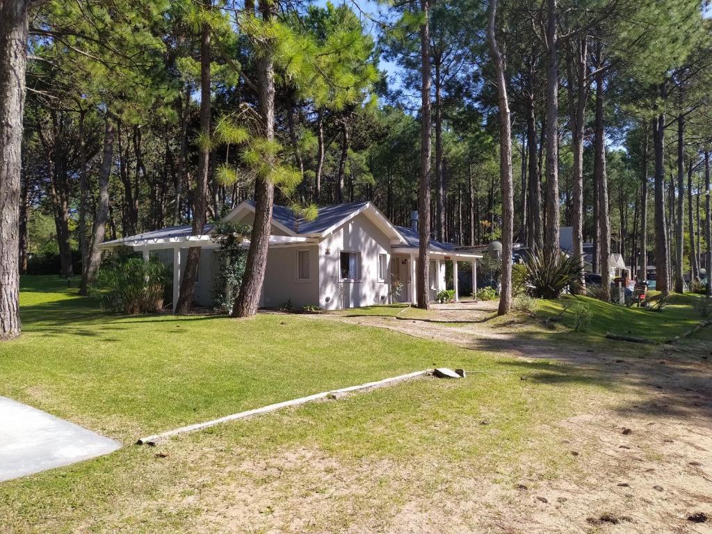 una casa nel bosco con un cortile di Pinamar Norte Casa Aquiles 8 pax a Pinamar