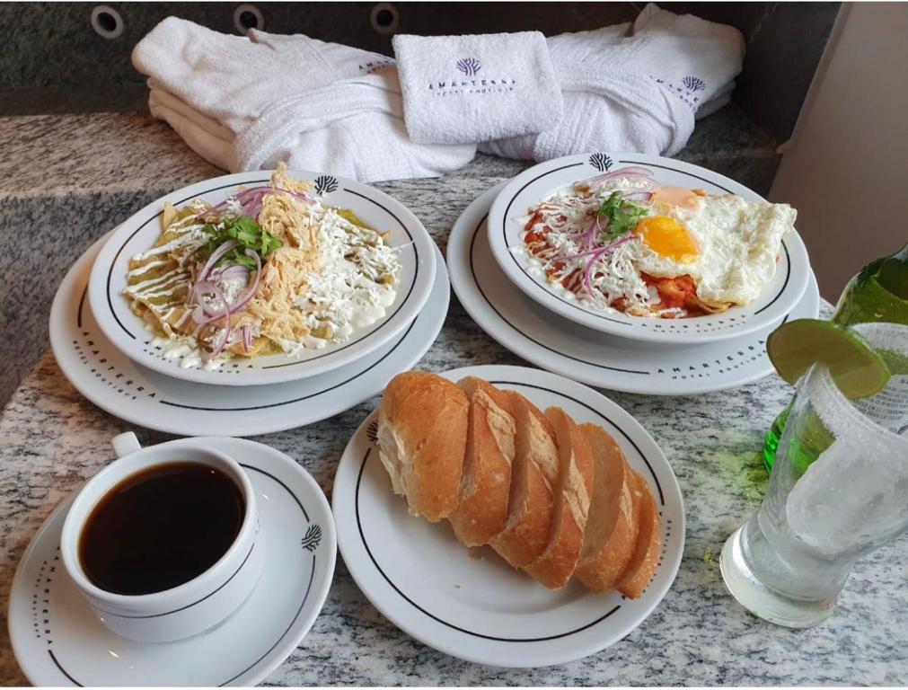 una mesa con platos de comida y una taza de café en Amarterra Hotel Boutique en Ciudad de México