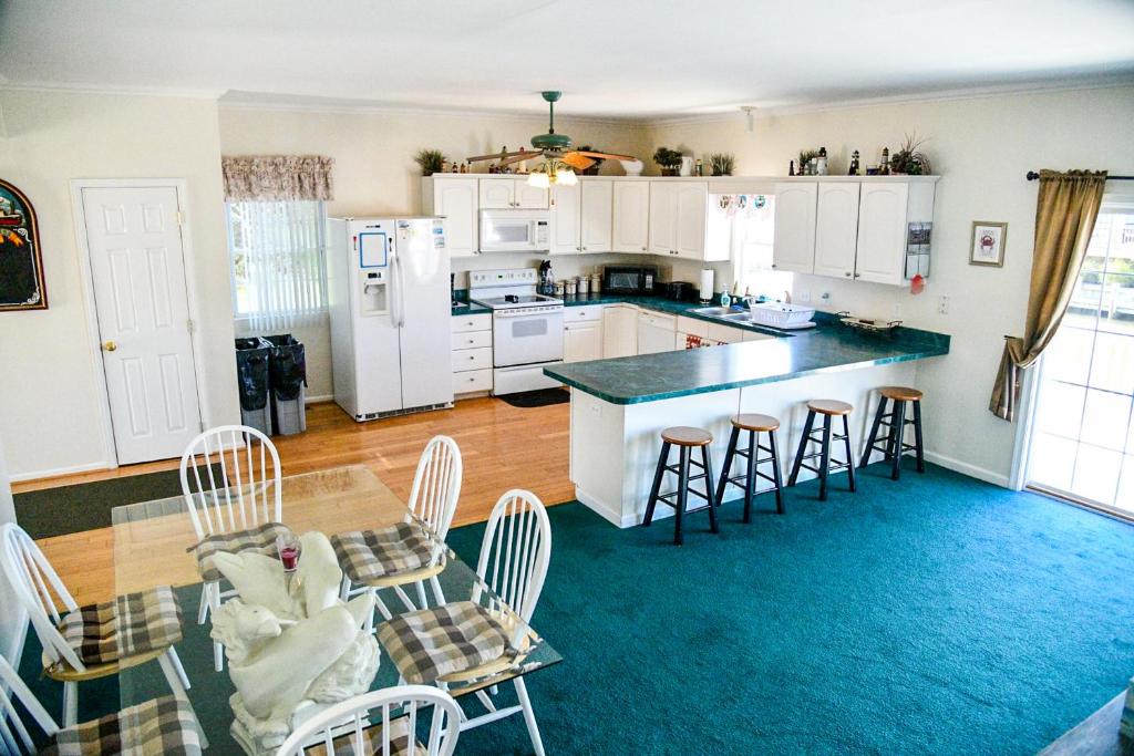 a kitchen with white cabinets and a table and chairs at Bayside View in Ocean City
