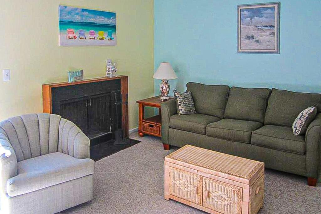 sala de estar con sofá, silla y chimenea en Villas of Bethany West -- 722C Treetop, en Bethany Beach