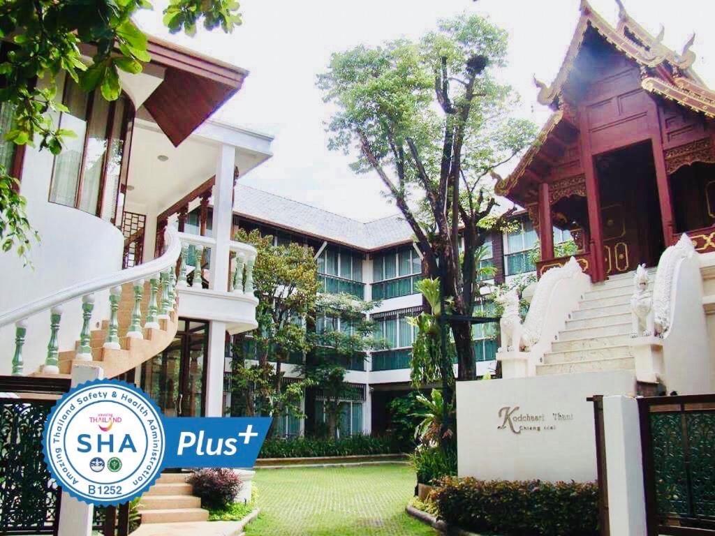 ein Hotel mit einem Schild vor einem Gebäude in der Unterkunft Kodchasri Thani Hotel Chiangmai - SHA Extra Plus in Chiang Mai