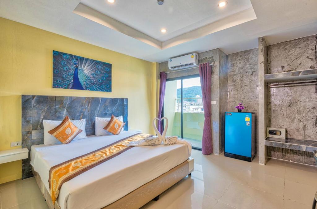 a bedroom with a large bed and a television at TJ Patong Hotel - Otop Shopping Paradise in Patong Beach