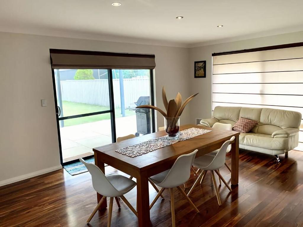 uma sala de estar com uma mesa, cadeiras e um sofá em Wagon Holiday Home em Broadwater