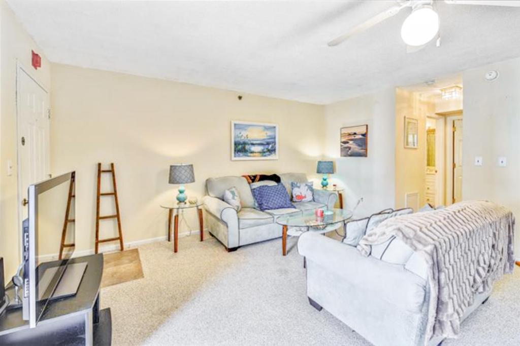 a living room with two couches and a tv at Sandalwood 203B in Ocean City