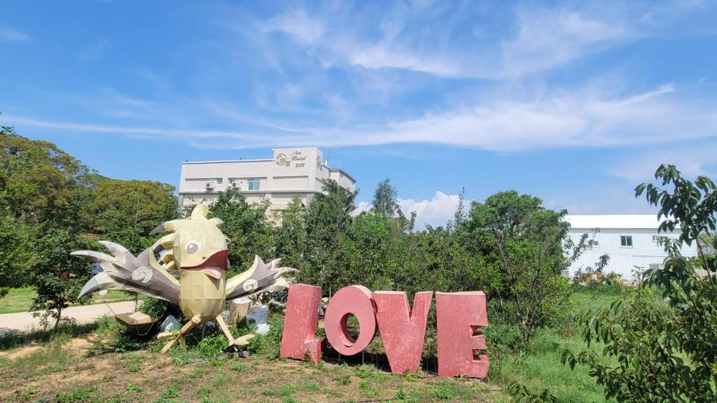 a sign that says love next to a statue of a lizard at 好宿民宿 in Jinning