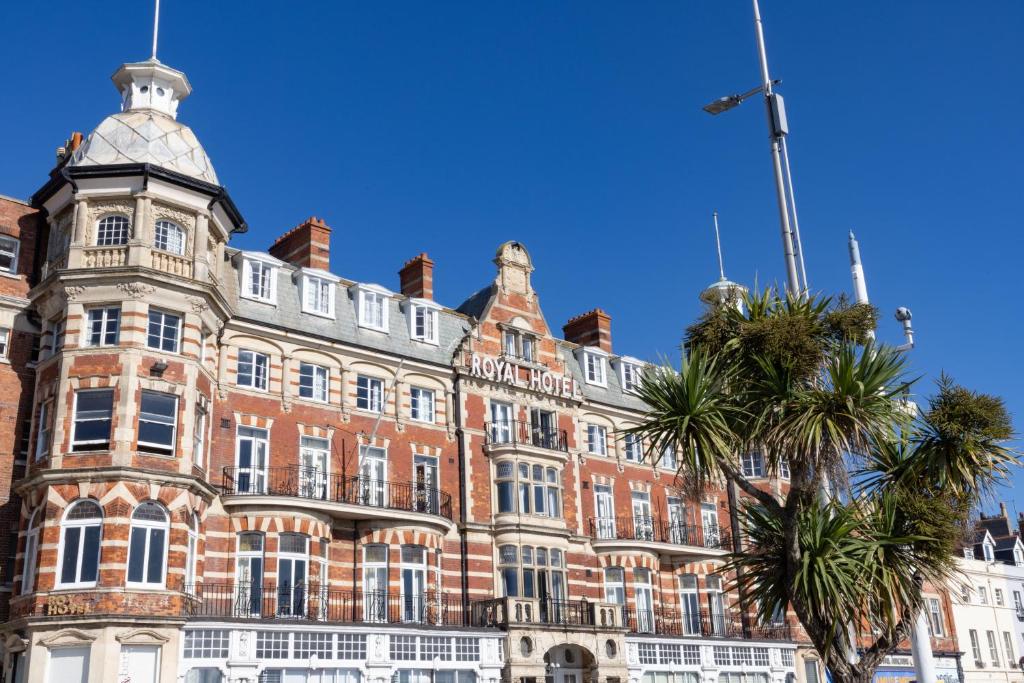 a large brick building with a clock tower at The Royal Hotel Weymouth in Weymouth