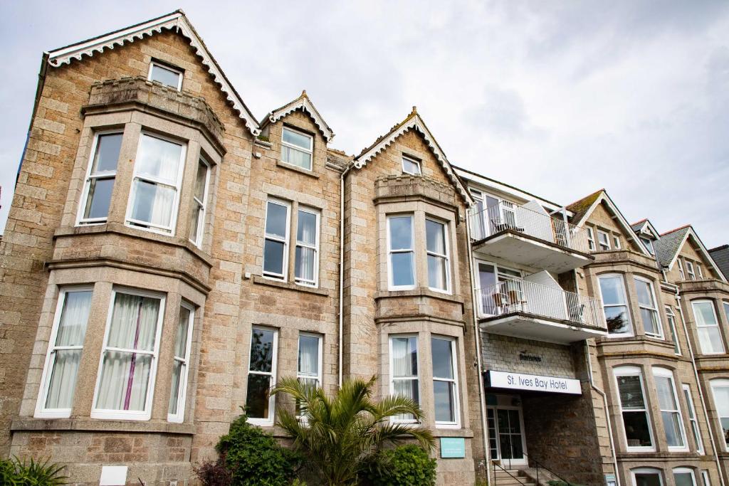 a large brick building with windows and plants at The St Ives Bay Hotel in St Ives