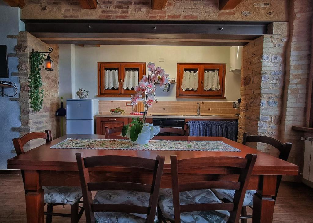 kuchnia z drewnianym stołem i krzesłami oraz kuchnia z blatem w obiekcie La scuola del castello località San Giovanni Spello w mieście San Giovanni