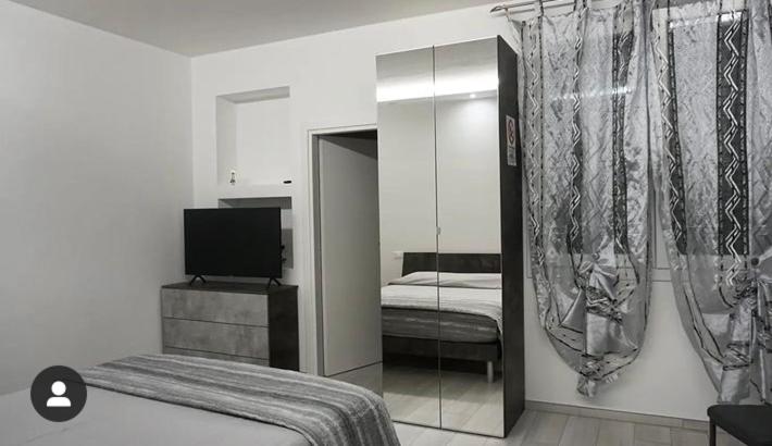 una camera con 2 letti, una TV e uno specchio di RoomsCarli a Comacchio