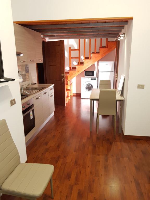 聖圖費米亞拉梅齊亞的住宿－Modern Apt REVENTINO - Le Lincelle, Lamezia，厨房以及带桌子和楼梯的用餐室。