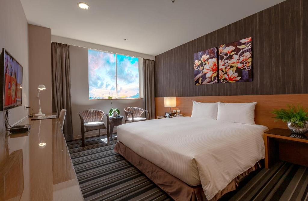 um quarto de hotel com uma cama grande e uma janela em Guide Education Culture Hotel Kaohsiung Museum of Fine Arts em Kaohsiung