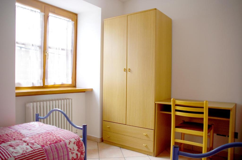 sypialnia z łóżkiem, biurkiem i szafką w obiekcie Appartamenti -Casa Nicolussi- w mieście Molveno