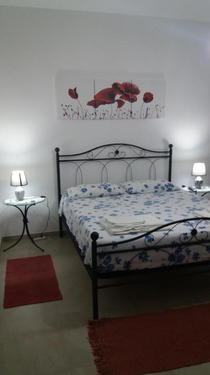 ガリポリにあるBaia Verde - Casa delle Magnolieのベッドルーム1室(ベッド1台、ランプ2つ付きのテーブル付)