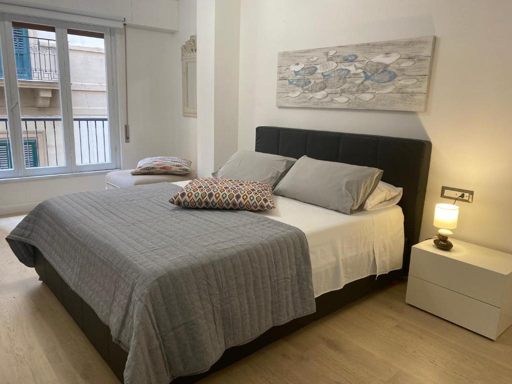 ein Schlafzimmer mit einem Bett mit zwei Kissen darauf in der Unterkunft Delle Palme Rooms elegante monolocale in centro in Palermo