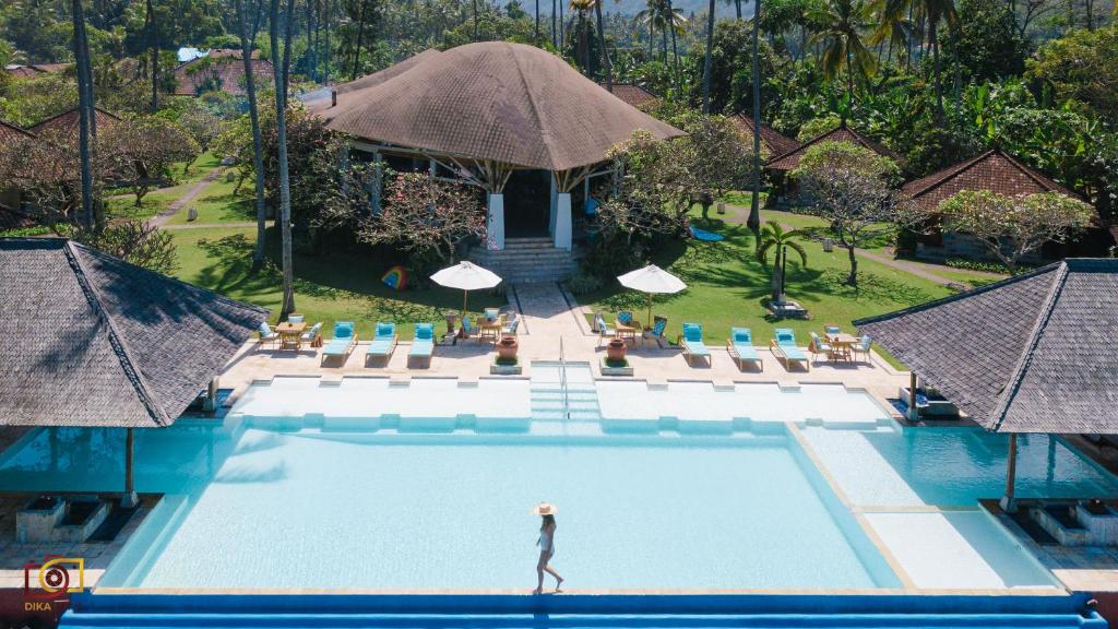 una mujer parada en una piscina en un resort en Lotus Bungalows, en Candidasa
