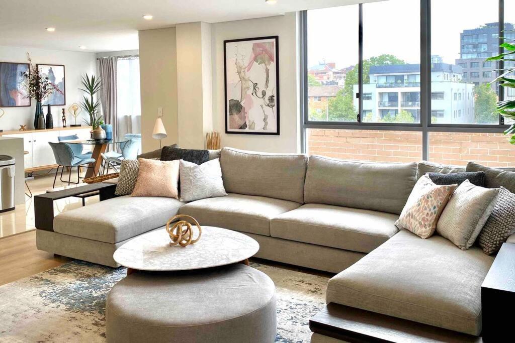 a living room with a couch and a table at Crows Nest - Executive Penthouse - 3 Bedroom- 5km to City in Sydney
