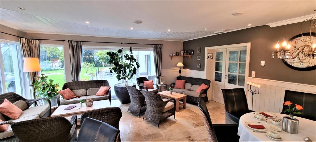 a living room filled with furniture and a fireplace at Hotel Eifelland in Butgenbach