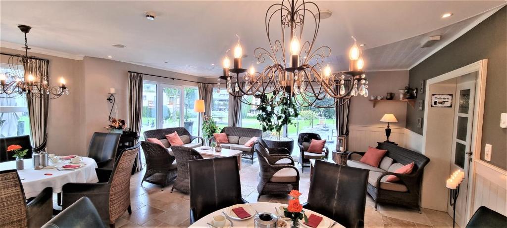 a living room filled with furniture and a chandelier at Hotel Eifelland in Butgenbach