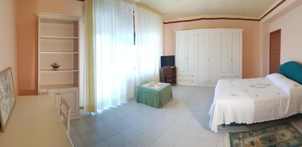 Stylish Apt TERINA - Le Lincelle, Lamezia - bright, spacious, elegant and with terrace في سانت أوفيميا لاميتسيا: غرفة نوم بسرير ونافذة كبيرة