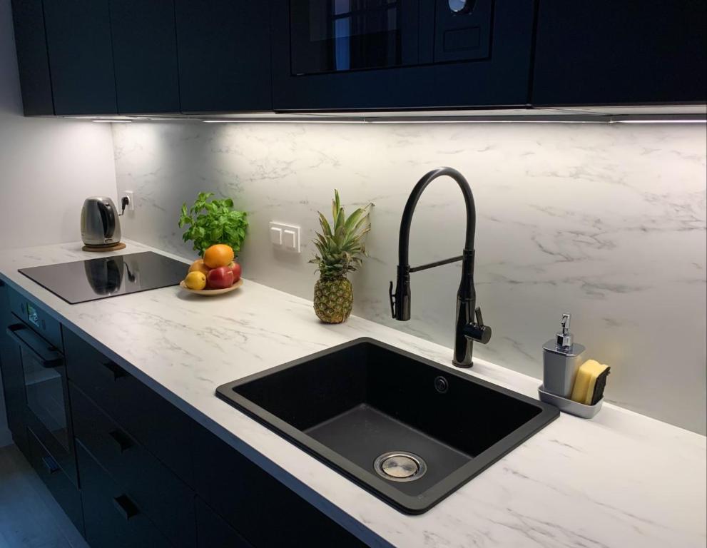 a kitchen counter with a sink and fruit on it at Apartament Voila in Warsaw