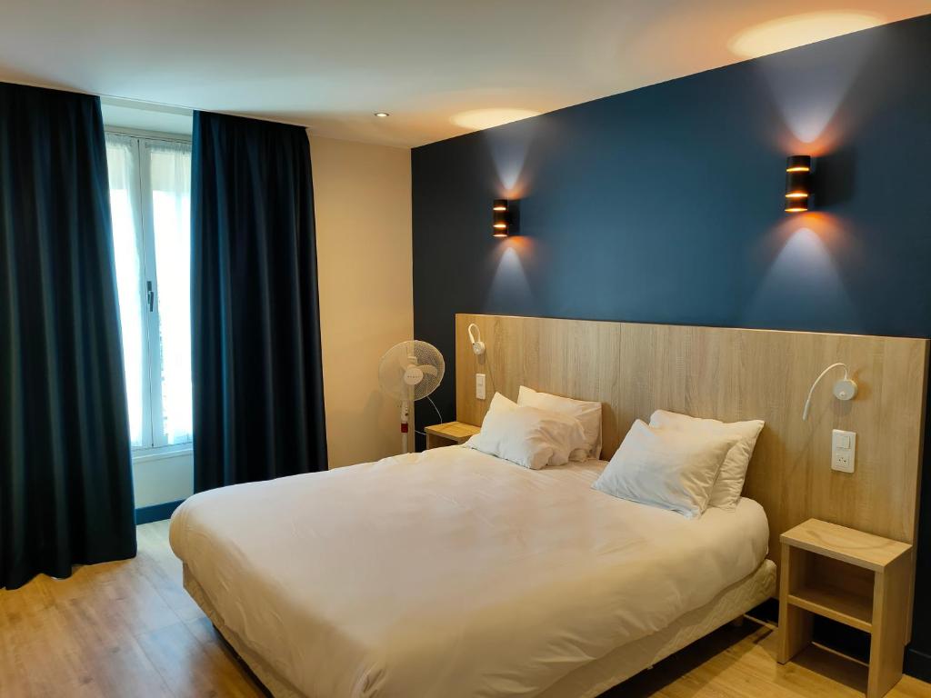 a bedroom with a large white bed with a blue wall at Hotel Modern Est in Paris