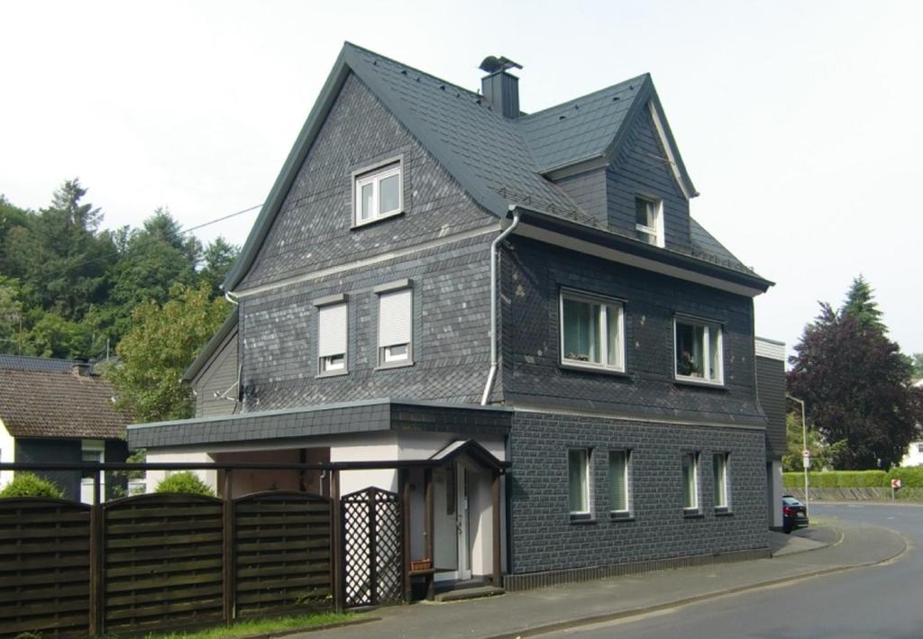 a black house with a gray roof at Ferienwohnung Ilse und Eberhard Tröps in Siegen