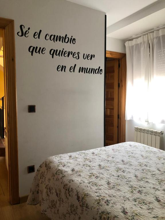 a bed room with a white bedspread and a white wall at De Sol A Sol in Hornillos del Camino