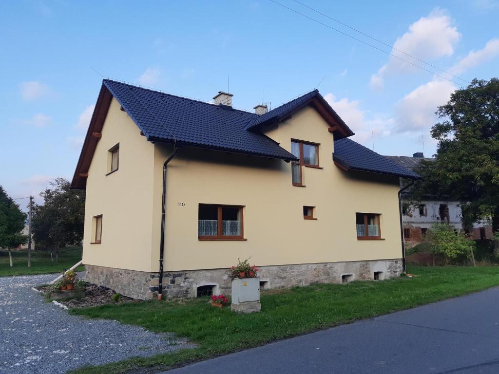 uma grande casa branca com um telhado preto em Apartmány u Mlýna em Velké Losiny