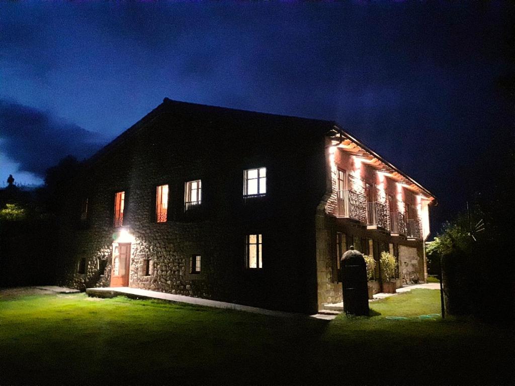 una casa iluminada por la noche con luces en LA POSADA DEL TENOR, en Molledo