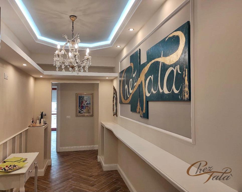 a hallway with a chandelier and a painting on the wall at Chez Tata' - Scé Tatà in Rossano Stazione