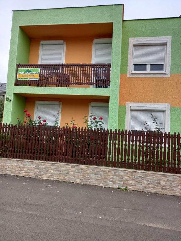 ハイドゥソボスローにあるPark Apartmanの木塀のある緑とオレンジの家