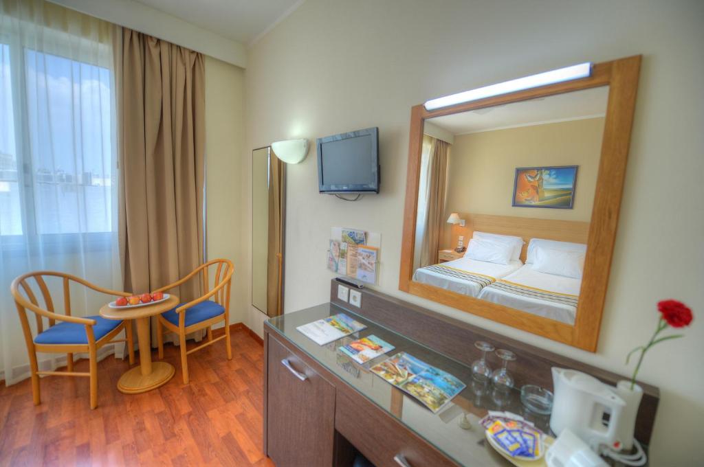 a hotel room with a bed and a mirror at The Preluna Hotel in Sliema
