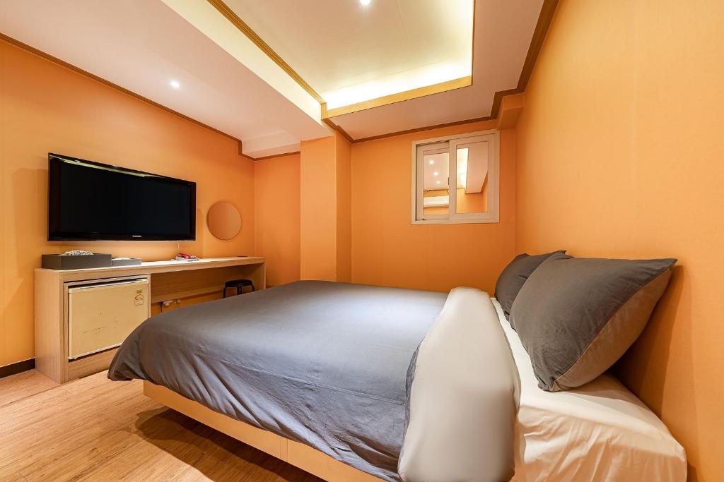 a small bedroom with a bed and a television at Hngstay in Seoul