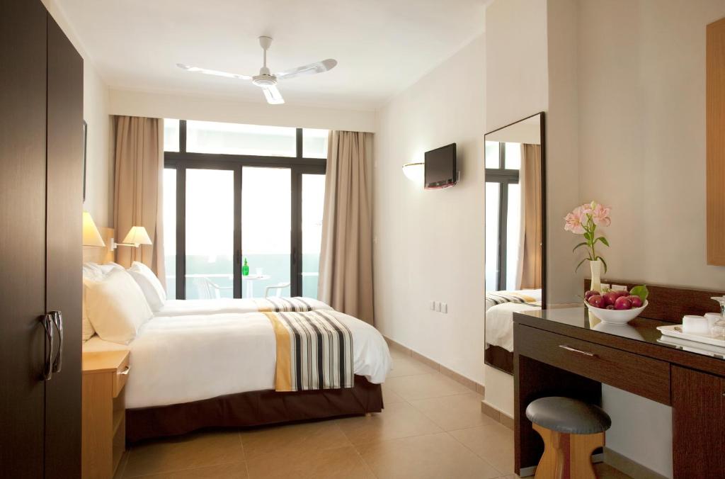 a hotel room with a bed and a mirror at The Preluna Hotel in Sliema