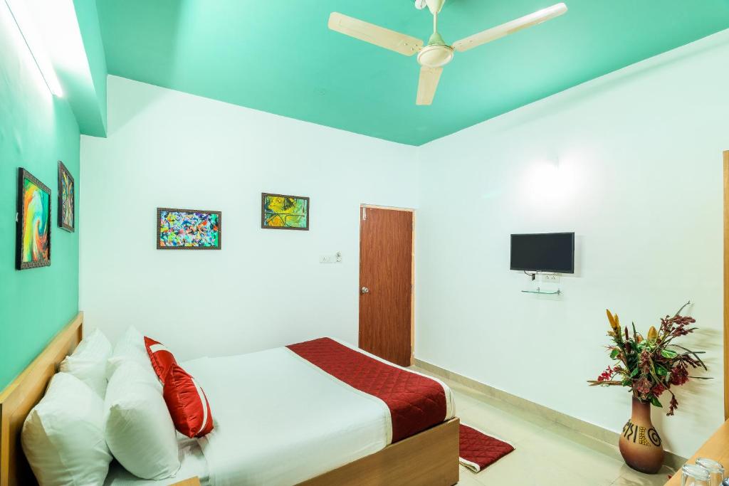 a bedroom with a bed and a ceiling fan at Octave Paris Residency in Bangalore