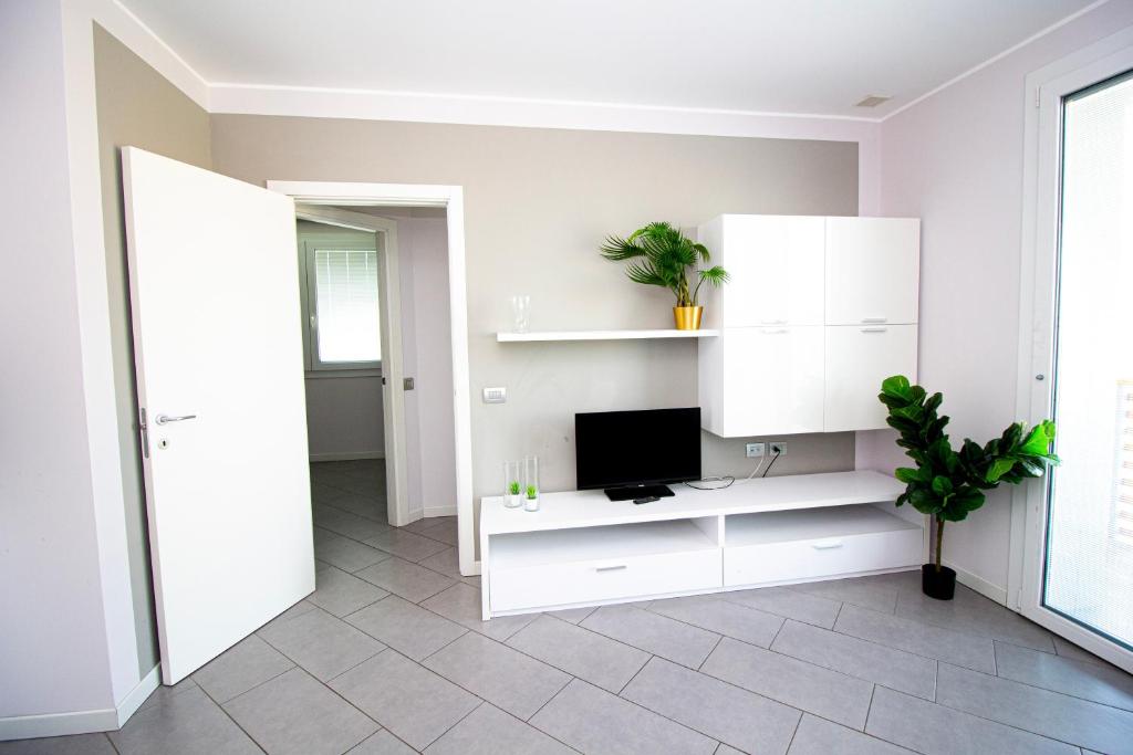 a living room with a tv and white cabinets at The Residence Galliate in Galliate