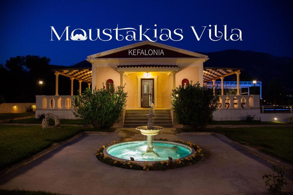 a villa with a fountain in front of a building at Moustakias Villa in Kefallonia