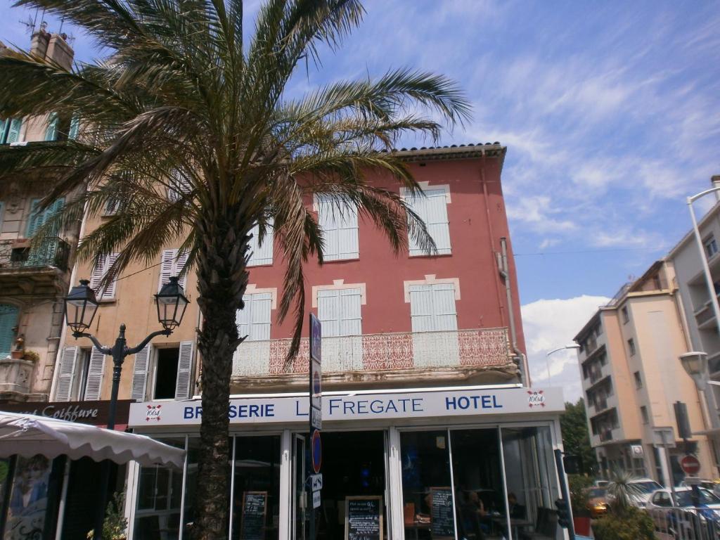 un palmier en face d'un hôtel dans l'établissement Hotel Restaurant La Frégate, à La Seyne-sur-Mer