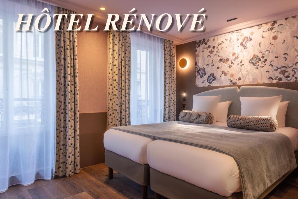 una habitación de hotel con una cama y un letrero en la pared en Maison Axel Opéra, en París