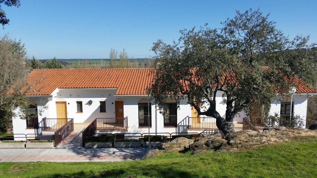 une maison blanche avec un toit orange dans l'établissement Apartamentos Baños de Ledesma, à Salamanque